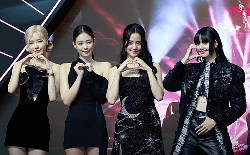 BLACKPINK members posing on the pink carpet at an official event