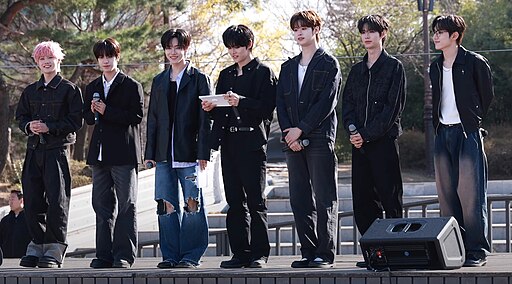 Members of CLOSE YOUR EYES posing in coordinated white and black outfits.