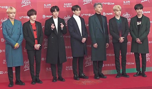 BTS on the red carpet at the 33rd Golden Disc Awards, wearing stylish suits and posing for the media.