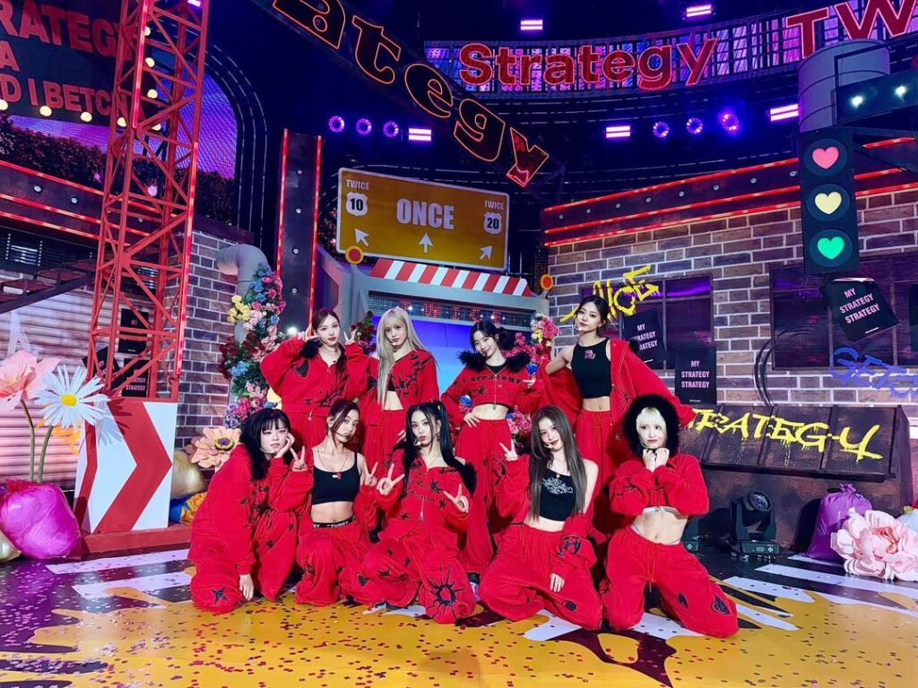 TWICE members pose for a behind-the-scenes moment, showcasing their natural charm.