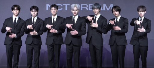 NCT DREAM members pose together during the DREAM()SCAPE press conference in coordinated black outfits.